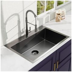 a stainless steel kitchen sink with faucet and soap dispenser next to it