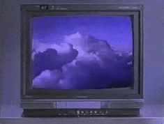 an old television with clouds on the screen