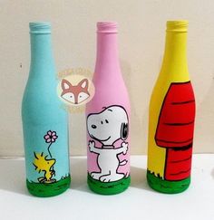 three colorful bottles with cartoon characters painted on them, one has a dog and the other is a cat