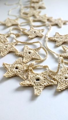 crocheted ornaments are arranged on a white table top, including one star ornament