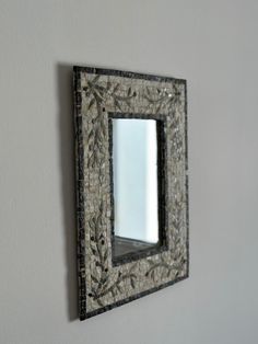 a mirror mounted on the wall above a sink in a room with gray walls and white trim