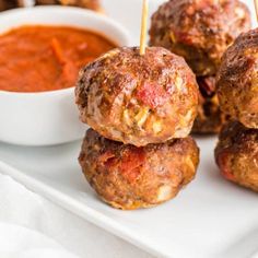 several meatballs on a plate with dipping sauce