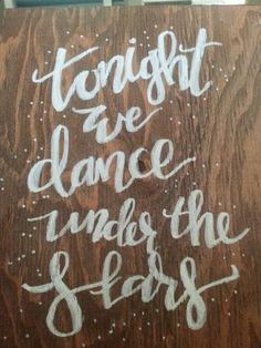 a wooden sign that says tonight we dance under the stars on it's side