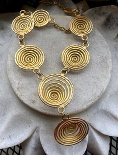 Modernist Egyptian Revival Gold Gilt Coil Spiral Vintage Bib Necklace Necklace is adjustable , measures 16 inches around the neck the front drop measures over 2 inches Beautiful, well done Elegant Adjustable Swirl Necklace, Unique Swirl Shaped Metal Jewelry, Unique Swirl Metal Jewelry, Adjustable Spiral Gold Necklace, Unique Gold Spiral Necklace, Adjustable Gold Spiral Necklace, Spiral Brass Jewelry, Adjustable Metal Swirl Jewelry, Unique Spiral Jewelry For Festivals