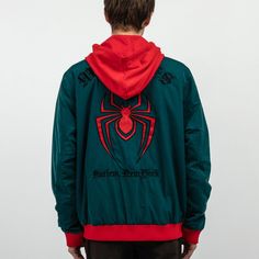 a man wearing a green and red spiderman jacket