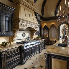 an ornate kitchen with black cabinets and marble counter tops, chandelier above the stove