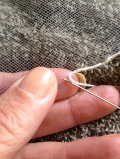 someone is stitching something on the side of a piece of fabric with a needle