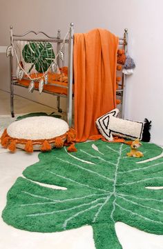 a bedroom with green and white rugs on the floor next to a metal bed