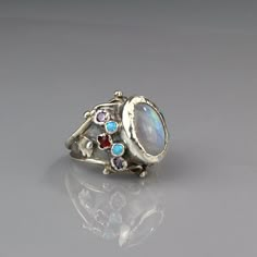 "Moonstone Engagement Ring, Moonstone Birthstone, Engagement Ring, Queen Ring, Adjustable Ring, Silver Statement Ring, Antique Style, Gift Unique antique style hand crafted ring for brides to be! A rainbow moonstone ring will make you feel like a real queen on your special day! This eye-catching statement ring is made of sterling silver bezel with a handcrafted setting of fascinating rainbow moonstone gemstone (center stone), lab opal, carnelian and purple zircon. Measurements: Center stone - 10 Luxury Vintage Moonstone Gemstone Ring, Luxury Vintage Moonstone Ring With Polished Finish, Unique Opal Ring With Moonstone, Unique Wedding Moonstone Ring With Gemstone Accents, Unique Moonstone Ring With Gemstone Accents For Anniversary, Unique Open Moonstone Ring, Unique Moonstone Rings With Gemstone Accents, Unique Open Moonstone Ring With Cabochon Cut, Unique Moonstone Ring With Stone Setting