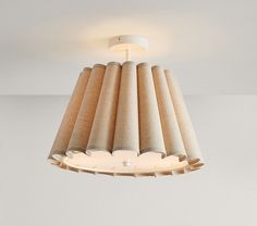 a light that is hanging from the ceiling in a room with white walls and flooring