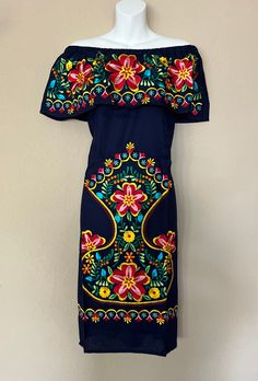 an off the shoulder dress with colorful flowers on it, hanging from a mannequin