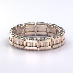 a gold bracelet is shown on a white surface, with the clasp closed to show it's rectangular shape