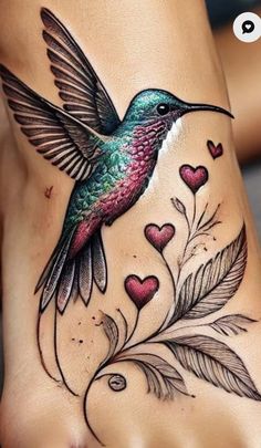 a woman's foot with a hummingbird and hearts tattoo on the side of her leg