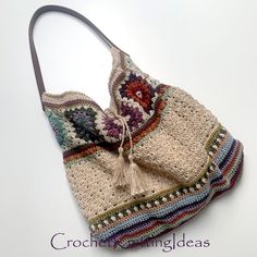 a crocheted purse with a tasselled handle