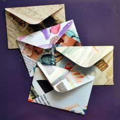 an open envelope with several pieces of paper sticking out of it on a purple surface