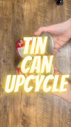 a person holding a can with the word tin can upcycle on it in front of them