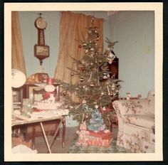 an old photo of a christmas tree in a living room