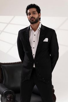 Black tuxedo with placement sequin and cutdana embroidery. Paired with a white shirt and pant.
Components: 3
Pattern: Embroidered
Type Of Work: Sequin, Cutdana
Neckline: Lapel collar
Sleeve Type: Long
Fabric: Terriwool and Cotton, Lining: Poly
Color: Black
Other Details: 
Attached poly lining
Approx. product weight: 3 kgs
Note: Pocket square shown in the image is not for sale.
Occasion: Cocktail and Reception - Aza Fashions Embroidered Tuxedo, Cutdana Embroidery, Tuxedo Pants, Black Tuxedo, Men's Suit, Pant Set, Shirt And Pants, Lapel Collar, Pocket Square