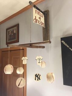 a baseball themed mobile hangs from the ceiling in a room with other items on it