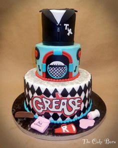 a cake that is sitting on top of a black and white plate with the words grease cake