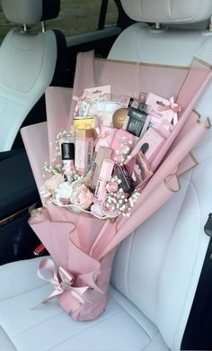 a pink bouquet sitting in the back seat of a car filled with personal care items