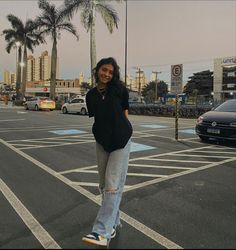 a woman is standing on her skateboard in the middle of an empty parking lot