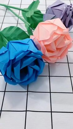 three origami roses sitting on top of a white tiled floor with the words follow for more like & save