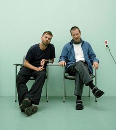 two men sitting next to each other in chairs