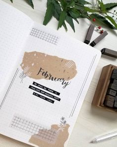 an open planner sitting on top of a desk next to a rubber stamp and pen