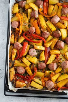 a pan filled with sausage, potatoes and peppers