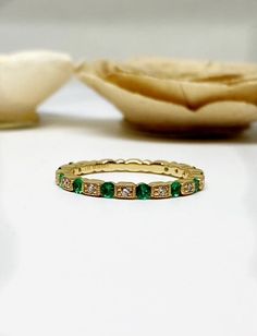 Art Deco Emerald green and diamond band. Material: 14k solid yellow gold.Colored stone: Genuine round emerald green stones going 3/4 of the way down.Emerald carat weight: 0.30 carats.Diamonds: Round diamonds. 0.10 carats total diamond weight.Width: 2mm wide.Comes in a nice box. Comes in white gold too. Stackable Diamond Bands, Emerald Green Stone, Art Deco Emerald, Round Diamonds Wedding Band, Morganite Engagement Ring Set, Emerald Gem, Stackable Bands, Green Stones, Ring Wedding Band