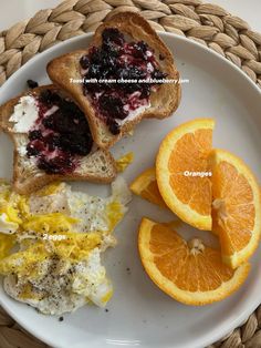 a plate with oranges, bread and other food items on it next to an orange slice