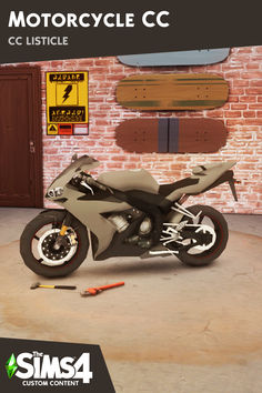 a motorcycle is parked in front of a brick wall and some tools are laying on the floor