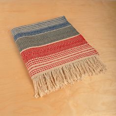 a red, white and blue blanket sitting on top of a wooden table