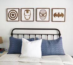 a bed with three framed pictures above it and two pillows on the bottom one side