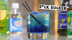 there is a blue drink in the glass with two black sticks sticking out of it