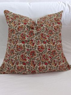 a decorative pillow on a white bed