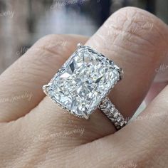 a woman's hand with a diamond ring on top of her finger and an engagement band