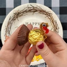 a person holding a piece of chocolate in front of a plate with some decorations on it