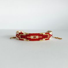 a red and white beaded bracelet sitting on top of a table