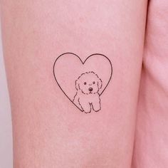 a small dog with a heart tattoo on its arm