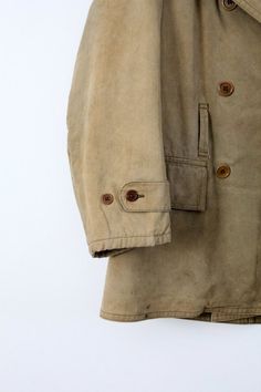 This is a vintage American army coat. The tan canvas coat features a thick olive wool lining and collar. The coat is double breasted with six buttons. There are pockets at the waist, buttons on the cuffs, and belt loops. CONDITIONIn good condition. There are two moth holes in the back of the collar, some marks on the sleeves, and a mark on the back left hip. No belt.Approximate Size: Men's MediumMEASUREMENTSBust:          22" (44)   ...     55.9 cm (111.8)Length:      32.5"      ...      82.6 cm Dystopia Clothes, Army Coat, Khaki Jacket, Men's Jackets, Winter Coats, Wool Jacket, American Vintage, Cargo Shorts, Military Jacket