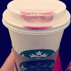 a starbucks cup with pink crayon on the lid and bottom half is shown