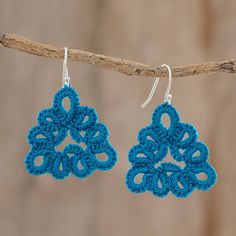 blue crocheted earrings hanging from a branch