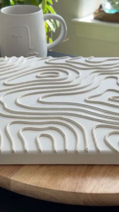 a close up view of a mattress on a table with coffee mugs in the background