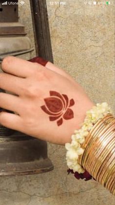 a woman's hand with a henna on it and a bell in the background