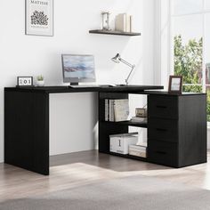 a black desk with drawers and a computer on it in front of a large window