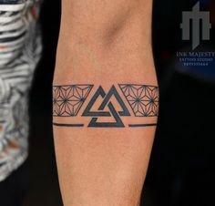 a tattoo on the leg of a man with geometrical shapes and triangles around it