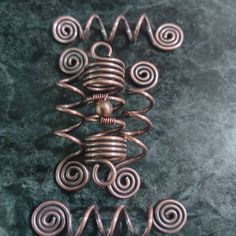 some type of metal object sitting on top of a green surface with spirals in the middle