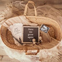 a basket filled with items on top of a wooden floor next to a sign that says our valentine is on the way